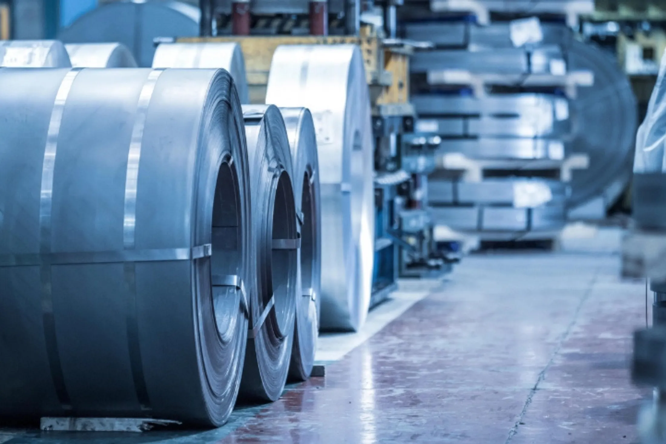Coiled metal sheets on a factory floor